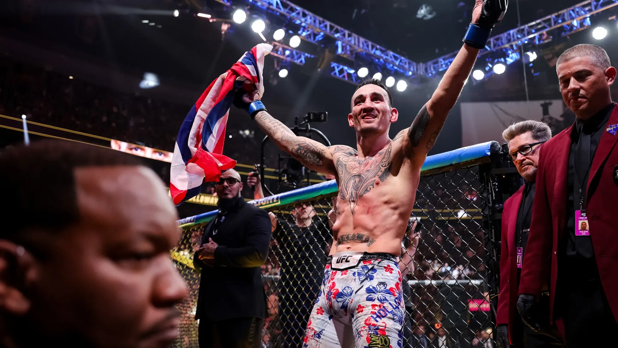 A fighter with his arms raised in the octagon as the decision is read.